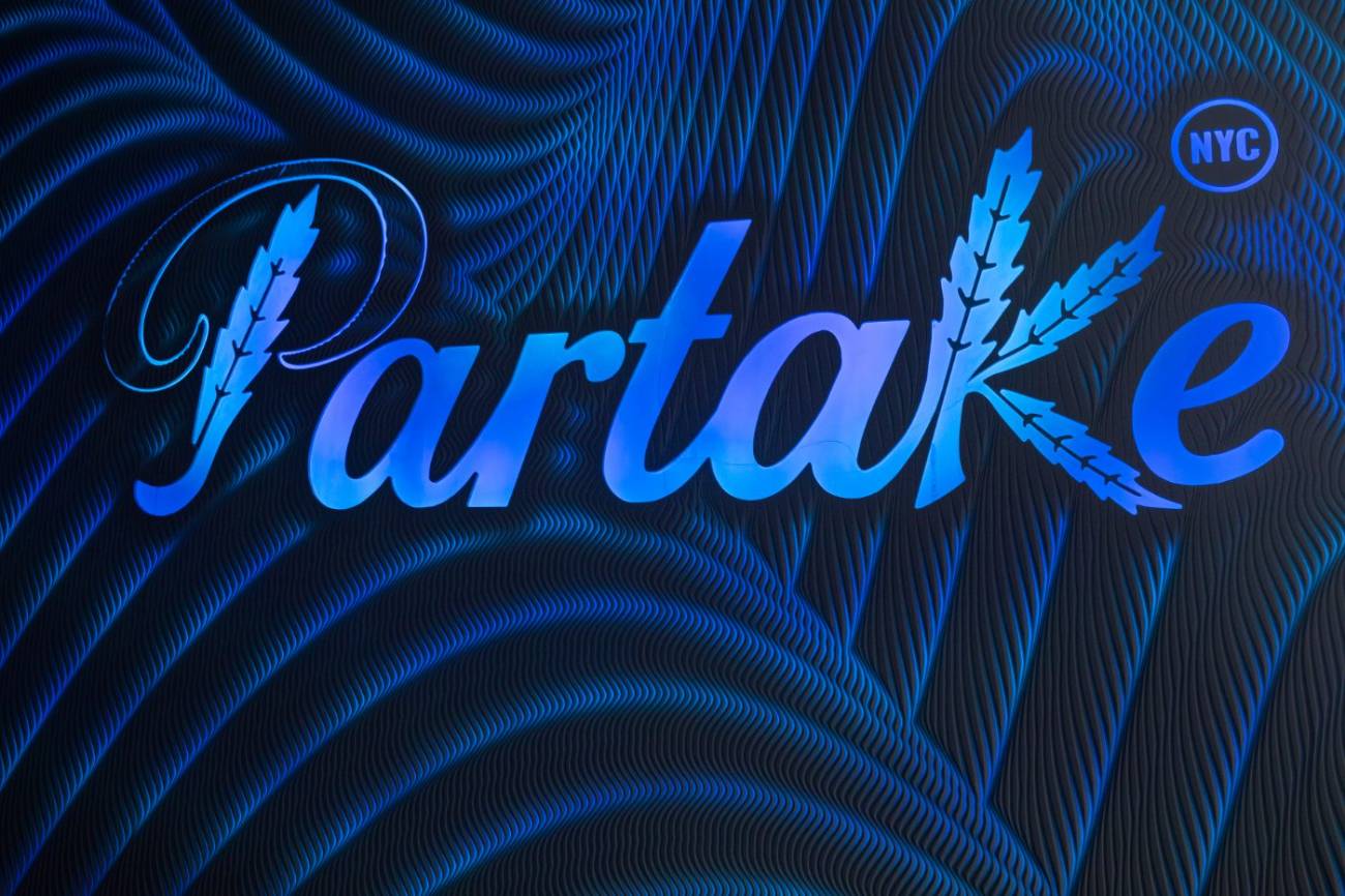 The Partake logo wall lit in blue