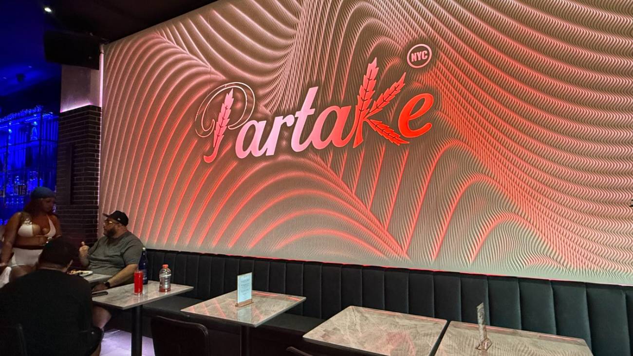 Tables along the illuminated Partake wall